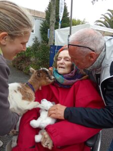UNE RESIDENTE CALINE UNE CHEVRE DE LA FERME ITINERANTE A SAINT POL DE LEON